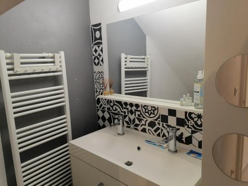 une salle de bain avec un lavabo et un miroir dans l'établissement La Taurelle, Maison T3 climatisée avec terrasse au cœur de Gallargues-le-Montueux, à Gallargues-le-Montueux