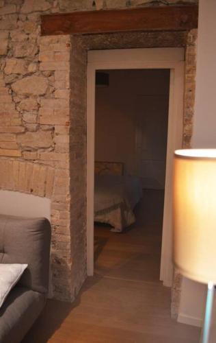 une chambre avec un mur en briques et une chambre avec un lit dans l'établissement Le Jaurès, logement d’exception, à Grenoble