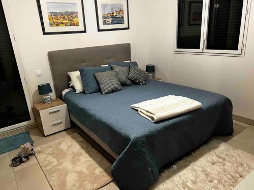 une chambre avec un lit avec des draps et des oreillers bleus dans l'établissement Beautiful Ocean View Home Overlooking Monaco, à Beausoleil