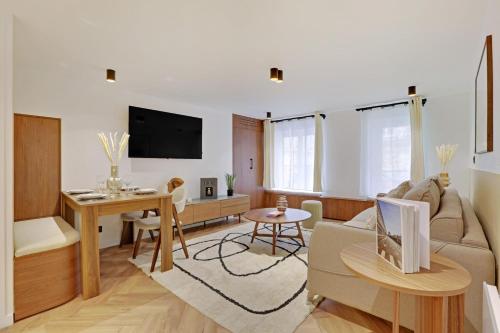 uma sala de estar com um sofá e uma mesa em Luxury appartement 1BR 4P - Petits Champs em Paris