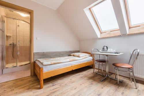 a bedroom with a bed and a shower and a table at Willa Diana- z panoramą jeziora i gór w Polańczyku in Polańczyk