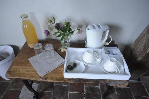 a table with a coffee maker and a tea pot on it at La ferme aux oiseaux B&B in Beaumont