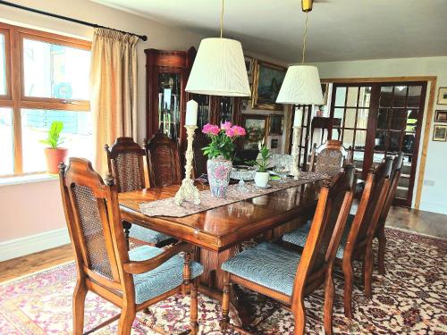 a dining room with a wooden table and chairs at Rural retreat near Knock in Ballyhaunis