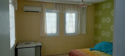 Habitación pequeña con 1 cama y 2 ventanas en ESKA 121 airport, en Dalaman