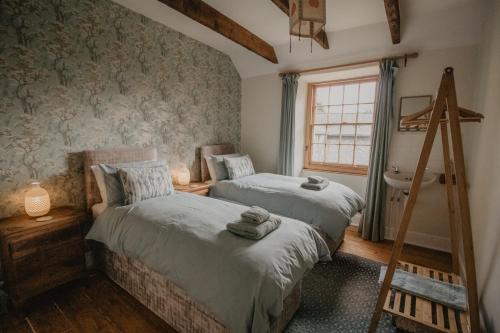 a bedroom with two beds and a window at Holwell Holistic Retreat in Barnstaple