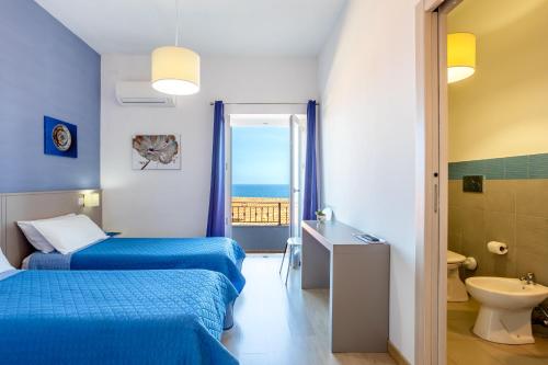 a hotel room with two beds and a bathroom at Appartamento Moderno con vista mare in Castelsardo