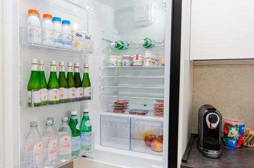 an open refrigerator filled with bottles and drinks at Schiaparelli 4 in Milan