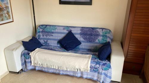 eine blaue und weiße Couch mit blauen Kissen darauf in der Unterkunft APARTAMENTO L'ESCALA in L'Escala
