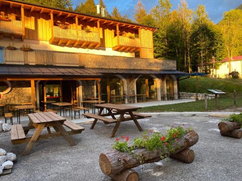 - deux tables de pique-nique devant un bâtiment dans l'établissement Rifugio Pian dei Ciclamini, à Lusevera