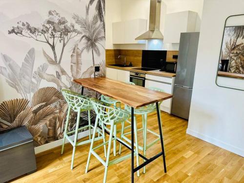 - une cuisine avec une table et des tabourets en bois dans l'établissement F2 Cosy Place Jean Jaurès, à Saint-Étienne