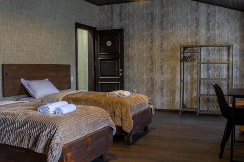 a bedroom with two beds and a table and a window at Hotel Eden in Mestia