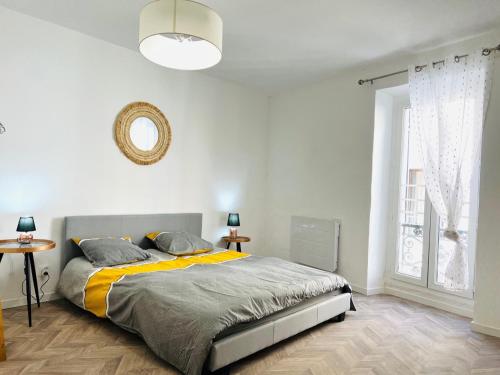 um quarto com uma cama e uma grande janela em Le "spacieux" en centre ville em Carpentras