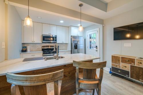a kitchen with a sink and two bar stools at Washington DC Gem with Fenced Backyard in Washington, D.C.