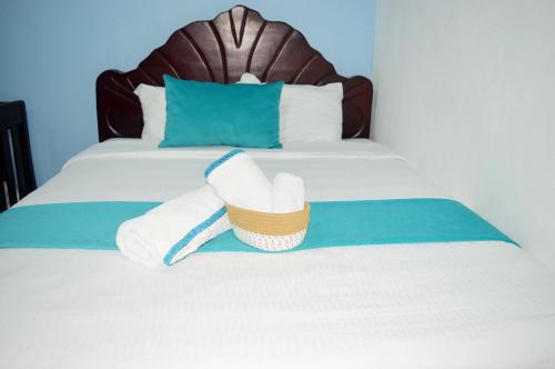 a bed with two towels and a basket on it at Apartamento Amueblado Mi Casa Caribe, Santo Domingo a 5 minutos del Aeropuerto Internacional de las Americas in Santo Domingo