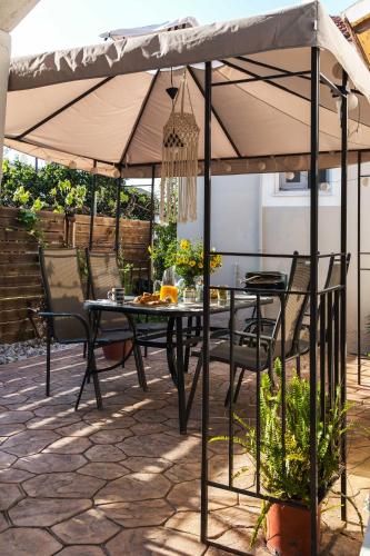 a table and chairs under an umbrella on a patio at Villa Agathi in Roda