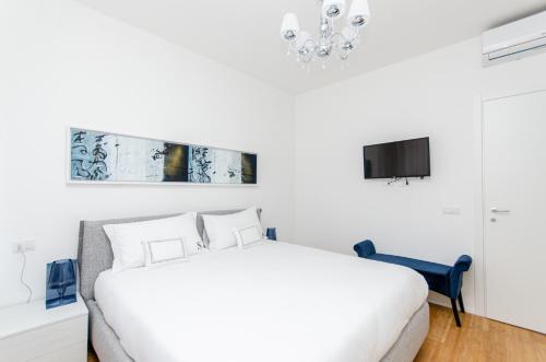 米蘭的住宿－Schiaparelli 4，一间白色卧室,配有床和电视