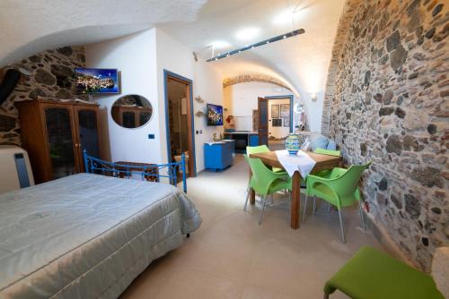 1 dormitorio con 1 cama, mesa y sillas en U Catoiu, en Scilla