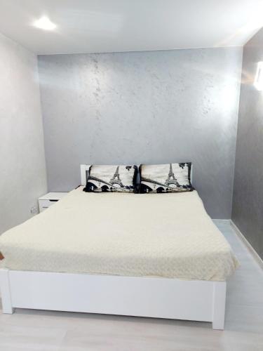 a white bed in a room with a wall at Lux apartment Sadovaya street in Mykolaiv