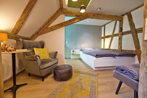 een slaapkamer met een bed, een stoel en een tafel bij Zinsers Appartements im Flämmle 