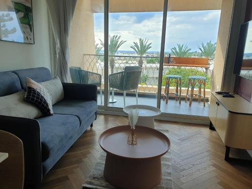 a living room with a couch and a view of a balcony at lasuita- exclusive suites cesarea- sea view suite in Caesarea