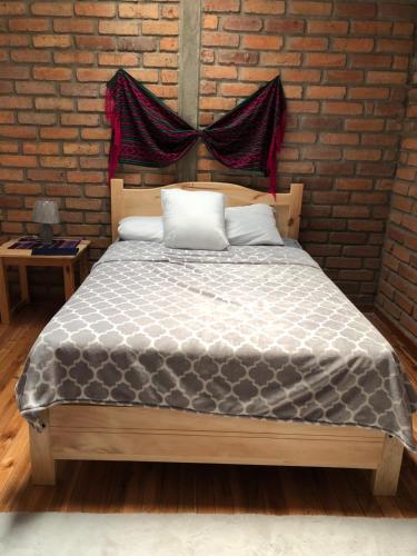 a bed in a room with a brick wall at Suite Bellavista Cuenca in Cuenca