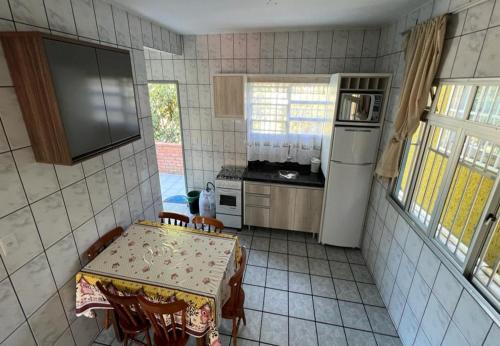 uma pequena cozinha com uma mesa e uma geladeira em Recanto do Martins em Florianópolis