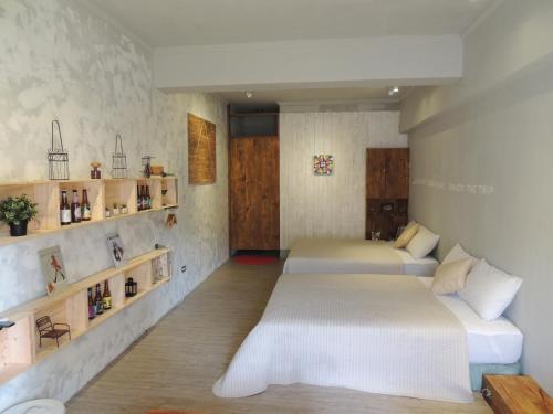 Cette chambre comprend 2 lits et des étagères murales. dans l'établissement The Moment, The Ocean B & B, à Nanwan