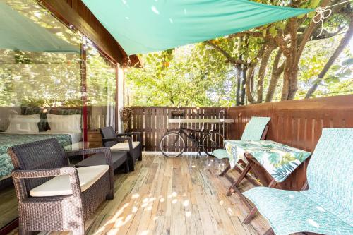a porch with chairs and a table and a bike at Casas Casal Do Carvalhal - Agroturismo in Amares
