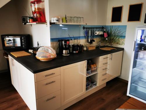 een keuken met een zwart aanrechtblad in een kamer bij Pension Zur Sülte in Sülte