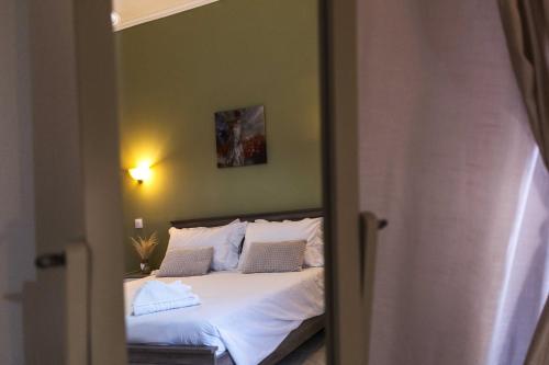 a bedroom with a bed with white sheets and pillows at Villa Agathi in Roda
