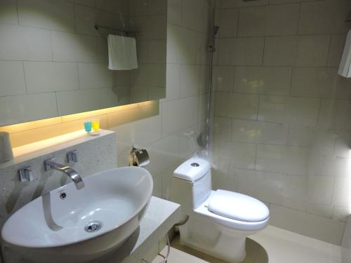 uma casa de banho branca com um lavatório e um WC em The Blanket Hotel Seberang Jaya em Perai