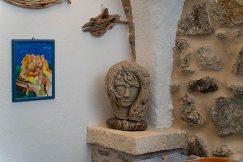 a statue next to a wall with a painting at U Catoiu in Scilla