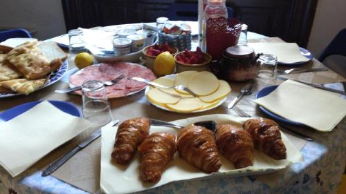 a table with plates of pastries and bread on it at B&B Amarantha Gothica Genoa in Genova