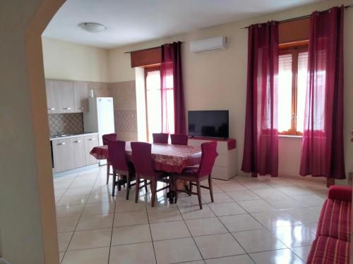uma cozinha com uma mesa de jantar e cadeiras roxas em Annalisa house 134 em Nápoles