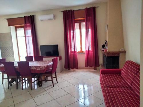 - une salle à manger avec des rideaux rouges, une table et des chaises dans l'établissement Annalisa house 134, à Naples