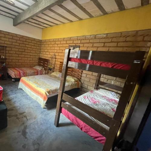 1 dormitorio con 2 literas y pared de ladrillo en Sítio Estrela da Manhã en Palmeiras