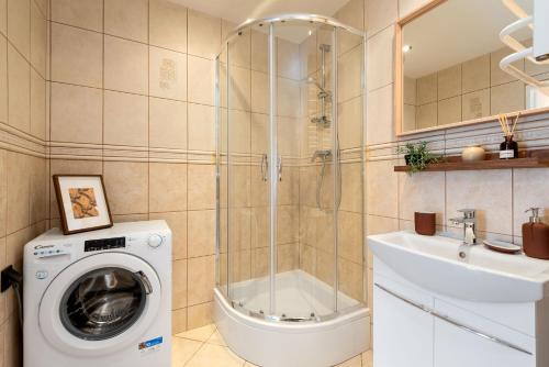 a bathroom with a washing machine and a sink at Apartament Family - darmowy Parking, blisko centrum - by Kairos Apartments in Gliwice