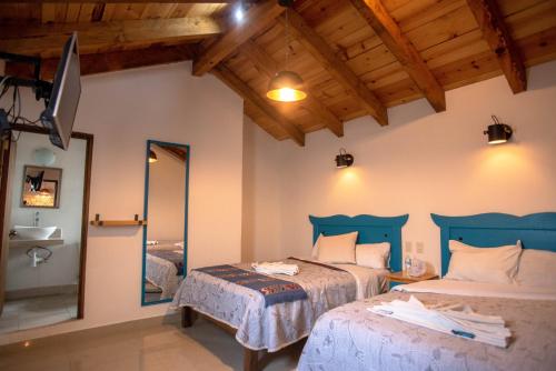 a bedroom with two beds and a mirror at Hotel Molino del Cerrillo in San Cristóbal de Las Casas