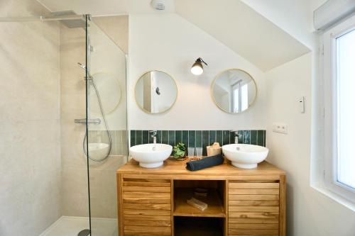 ein Badezimmer mit zwei Waschbecken und zwei Spiegeln in der Unterkunft Le Logis de la Mer in Concarneau