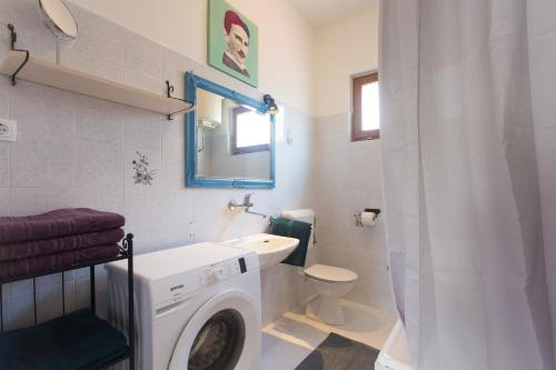 a bathroom with a washing machine and a sink at Holiday house VIDA in Biograd na Moru