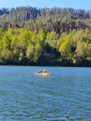 a group of people in a boat on a lake at Cabaña río Calle Calle in Valdivia