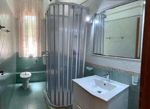 a bathroom with a sink and a shower and a toilet at Blue Coral in San Vito lo Capo