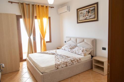 a bedroom with a bed and a window at Villa Dei Limoni in Durrës