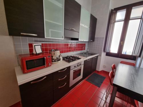 a kitchen with a red microwave and a stove at Sa domu de su beciu in Cagliari