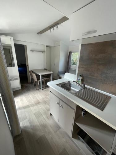 a small kitchen with a sink and a table at Mobil home en camping 4 étoiles à Bonne Anse Plage / La Palmyre in Les Mathes