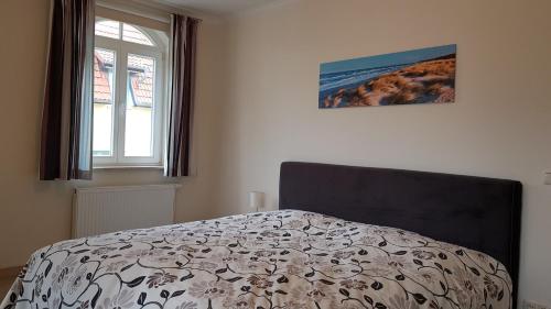 a bedroom with a bed with a black and white comforter at Strandküsschen in Kühlungsborn