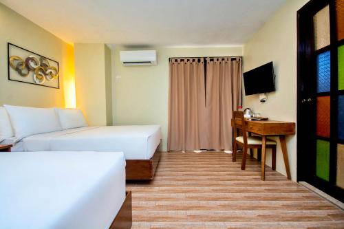 um quarto de hotel com duas camas e uma secretária em Serene La Playa Boracay em Boracay