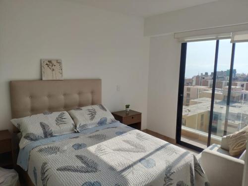 a bedroom with a bed and a large window at LOFT EN LIMA VISTA AL OCEANO - ¡Nuevo! Depa - Magdalena del Mar - in Lima