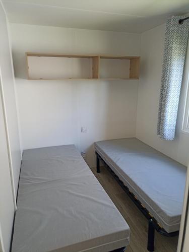 ゲランドにあるLe panoramaのベッド2台と窓が備わる小さな客室です。