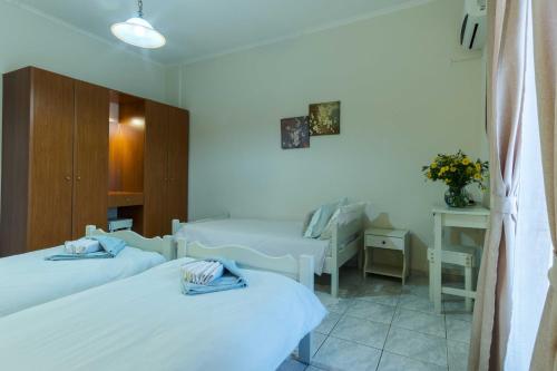 a hotel room with two beds and a table at Villa Agathi in Roda